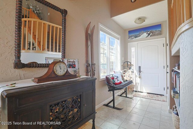 165 Cobble Creek Ln, Driggs, ID 83422 - foyer featuring a textured wall, baseboards, light tile patterned floors, and stairs