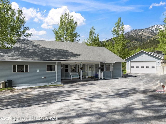 279 Vista E Dr, Star Valley Ranch, WY 83127 - view of front of property featuring a mountain view, a porch, an outdoor structure, and a detached garage