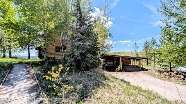10559 Rammell Mountain Rd, Tetonia, ID 83452 - view of front of house featuring a carport, driveway, and log siding