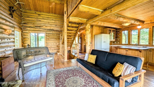 10559 Rammell Mountain Rd, Tetonia, ID 83452 - living area with wooden ceiling with exposed beams, light wood-type flooring, and log walls
