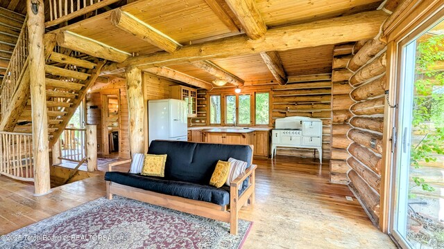 10559 Rammell Mountain Rd, Tetonia, ID 83452 - sitting room with wood ceiling with exposed beams, light wood-type flooring, log walls, and a large fireplace