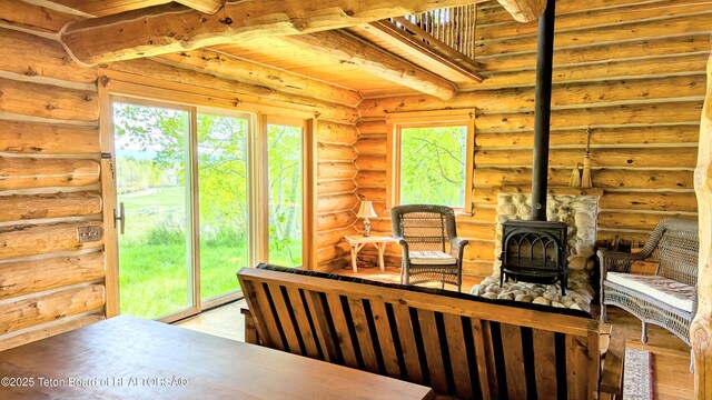 10559 Rammell Mountain Rd, Tetonia, ID 83452 - living area with a wood stove, light wood finished floors, wood ceiling, and rustic walls