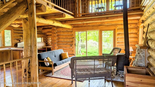 10559 Rammell Mountain Rd, Tetonia, ID 83452 - living area featuring hardwood / wood-style flooring, log walls, and a wood stove