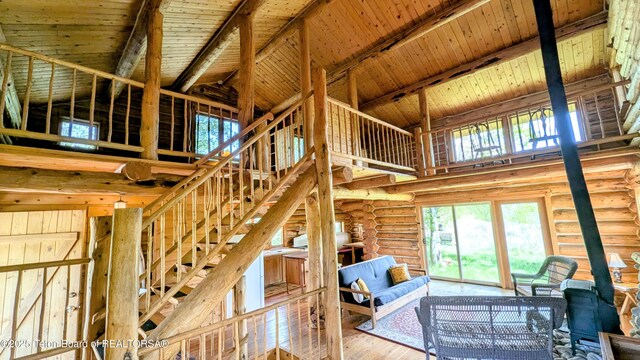 10559 Rammell Mountain Rd, Tetonia, ID 83452 - unfurnished living room featuring high vaulted ceiling, wooden ceiling with exposed beams, wood finished floors, and rustic walls