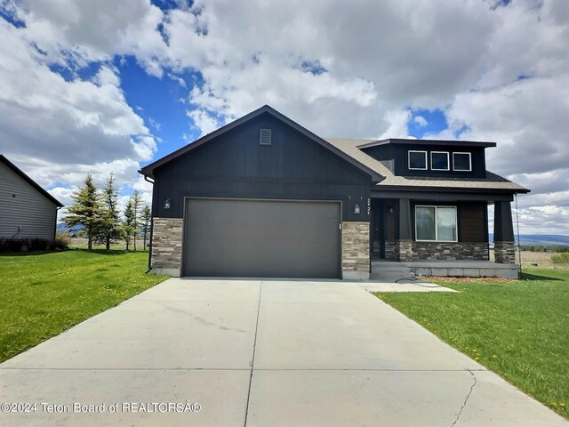 2929 Iron Wood Dr, Driggs, ID 83422 - view of front of property with stone siding, an attached garage, a front yard, and concrete driveway