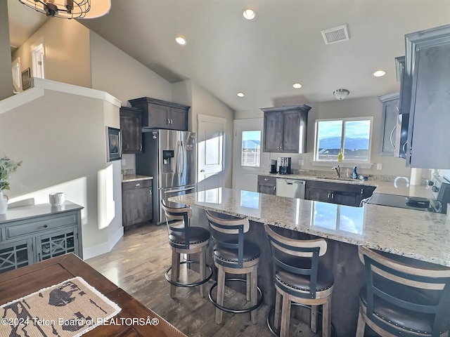 2929 Iron Wood Dr, Driggs, ID 83422 - kitchen with stainless steel appliances, a sink, a peninsula, light wood-type flooring, and light stone counters