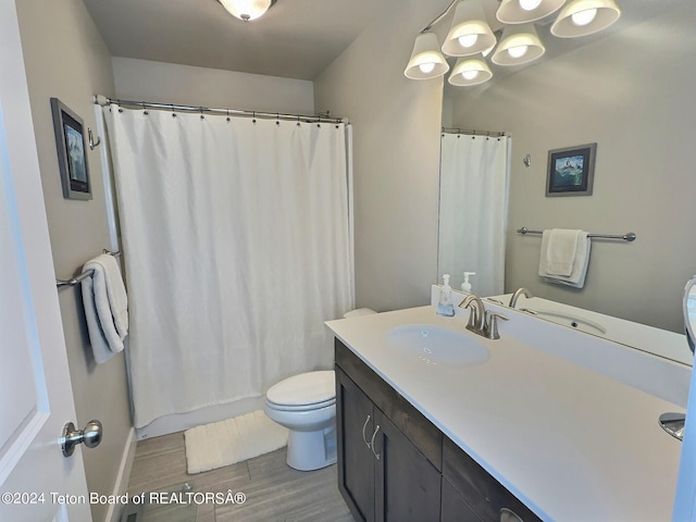 2929 Iron Wood Dr, Driggs, ID 83422 - full bathroom with toilet, vanity, wood finished floors, a shower with shower curtain, and baseboards