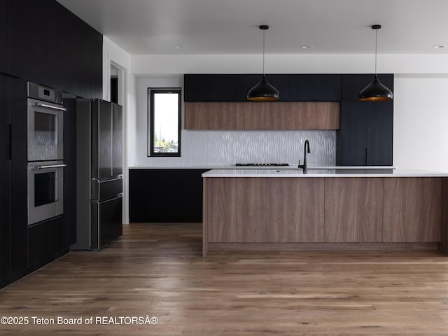 155 Sagewood Dr, Driggs, ID 83422 - kitchen featuring freestanding refrigerator, modern cabinets, double oven, light countertops, and light wood finished floors