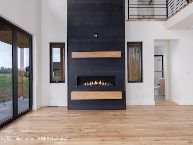 155 Sagewood Dr, Driggs, ID 83422 - unfurnished living room with a high ceiling, baseboards, wood finished floors, and a fireplace