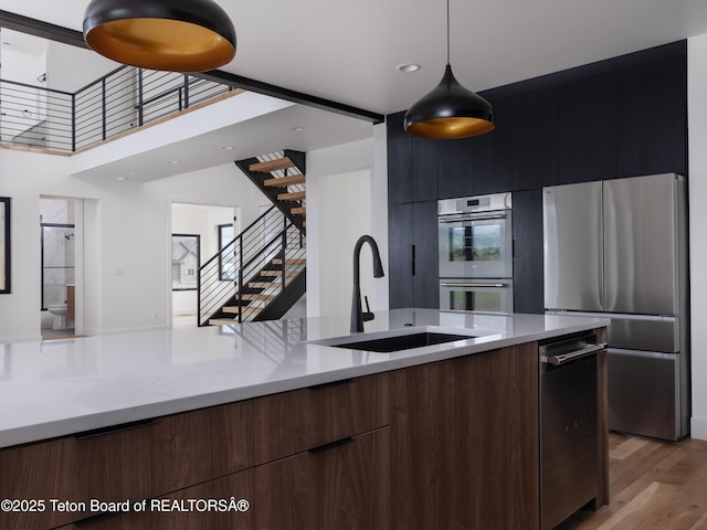 155 Sagewood Dr, Driggs, ID 83422 - kitchen with modern cabinets, stainless steel appliances, a sink, light wood-style flooring, and decorative light fixtures