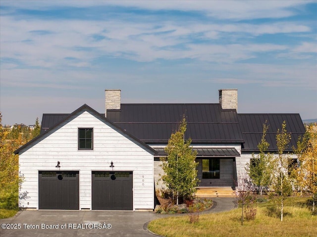900 Mountain Bluebird Ct, Driggs, ID 83422 - view of front facade featuring a chimney, a standing seam roof, asphalt driveway, and metal roof