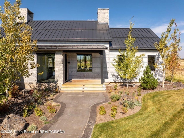 900 Mountain Bluebird Ct, Driggs, ID 83422 - view of exterior entry featuring a standing seam roof, a chimney, metal roof, and a porch