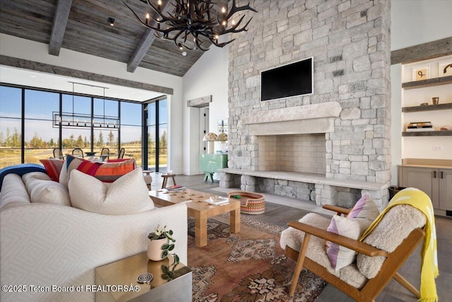 900 Mountain Bluebird Ct, Driggs, ID 83422 - living area with high vaulted ceiling, a chandelier, wood finished floors, beam ceiling, and a stone fireplace
