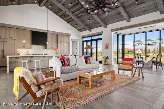 900 Mountain Bluebird Ct, Driggs, ID 83422 - living room with high vaulted ceiling, a chandelier, wooden ceiling with exposed beams, and light wood-style floors
