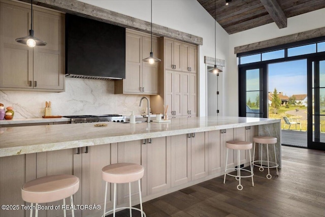 900 Mountain Bluebird Ct, Driggs, ID 83422 - kitchen with tasteful backsplash, dark wood finished floors, light stone countertops, wooden ceiling with exposed beams, and ventilation hood