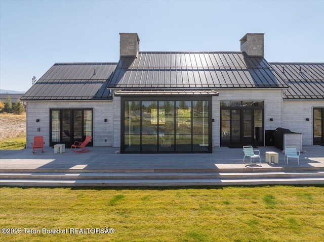 900 Mountain Bluebird Ct, Driggs, ID 83422 - back of house with a standing seam roof, a chimney, a wooden deck, and metal roof