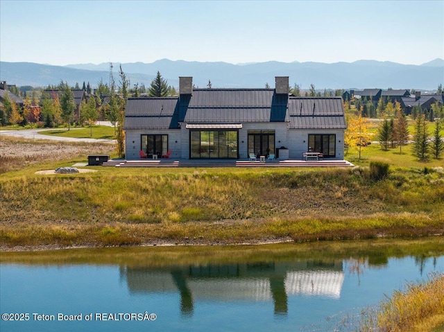 900 Mountain Bluebird Ct, Driggs, ID 83422 - rear view of property featuring a chimney, a standing seam roof, a water and mountain view, and metal roof