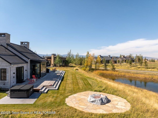 900 Mountain Bluebird Ct, Driggs, ID 83422 - view of grassy yard featuring a deck with water view and a fire pit