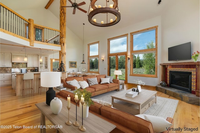 500 E Solitude Dr, Jackson, WY 83001 - living area with high vaulted ceiling, light wood-type flooring, a tile fireplace, beam ceiling, and a chandelier
