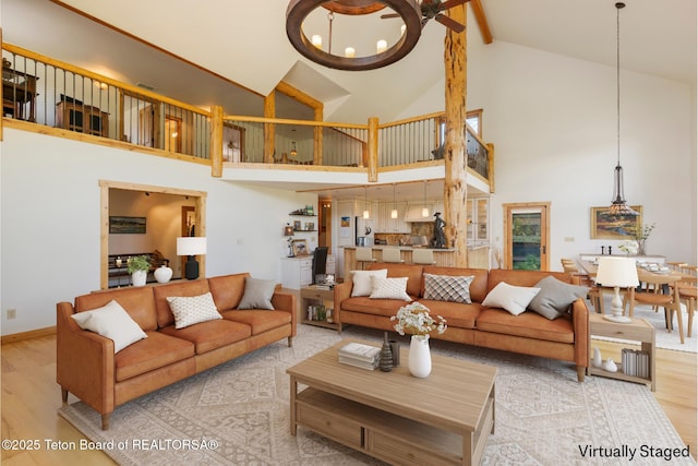 500 E Solitude Dr, Jackson, WY 83001 - living room with high vaulted ceiling, wood finished floors, a chandelier, beamed ceiling, and baseboards