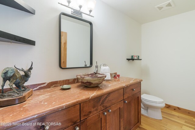 500 E Solitude Dr, Jackson, WY 83001 - half bathroom featuring wood finished floors, vanity, and toilet