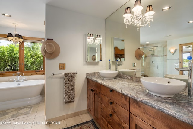 500 E Solitude Dr, Jackson, WY 83001 - bathroom with a chandelier, double vanity, a shower stall, tile patterned flooring, and a soaking tub