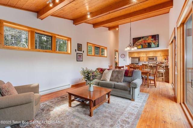 25655 Buffalo Run, Moran, WY 83013 - living area with baseboard heating, wood ceiling with exposed beams, light wood-type flooring, healthy amount of natural light, and a chandelier