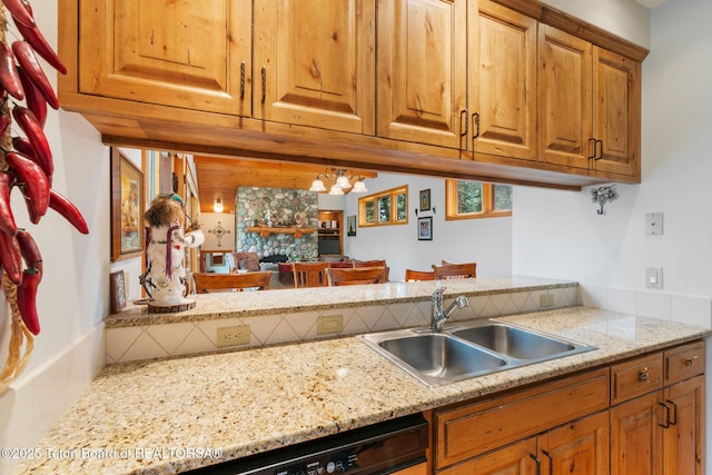 25655 Buffalo Run, Moran, WY 83013 - kitchen with a sink, a chandelier, brown cabinets, and light stone counters