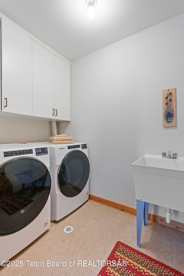25655 Buffalo Run, Moran, WY 83013 - laundry room with cabinet space, baseboards, and independent washer and dryer