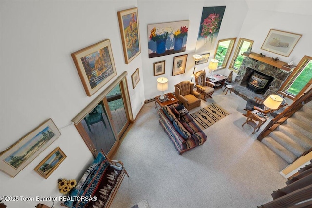 3470 S Winding Trail Dr, Jackson, WY 83001 - carpeted living area with a stone fireplace and a towering ceiling