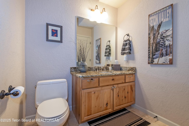 125 Cobble Creek Ln Unit 75, Driggs, ID 83422 - bathroom featuring vanity, toilet, tile patterned flooring, a textured wall, and baseboards