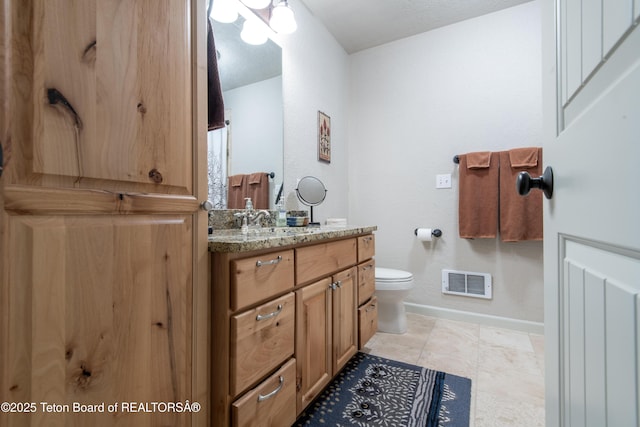 125 Cobble Creek Ln Unit 75, Driggs, ID 83422 - full bath featuring vanity, toilet, baseboards, and tile patterned flooring