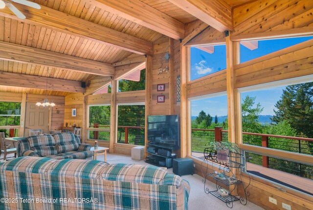 3190 Sorensen Creek Dr, Victor, ID 83455 - carpeted living room featuring a chandelier, wooden walls, wood ceiling, plenty of natural light, and a ceiling fan