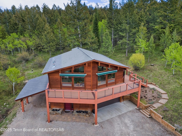 3190 Sorensen Creek Dr, Victor, ID 83455 - rear view of property with a carport, a wooded view, and driveway