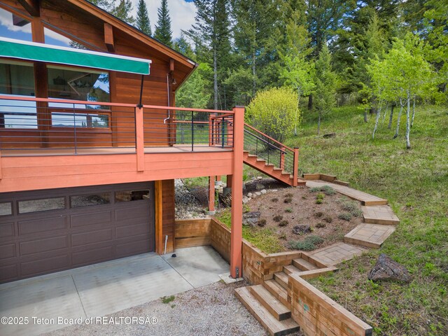 3190 Sorensen Creek Dr, Victor, ID 83455 - view of side of property featuring a garage, driveway, stairs, and a wooden deck