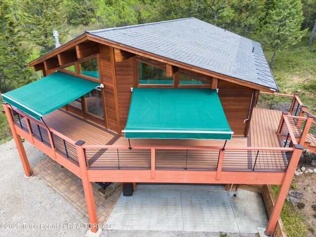 3190 Sorensen Creek Dr, Victor, ID 83455 - deck with a wooded view and a carport