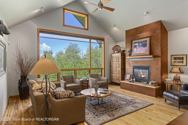 25000 N Deer Ct, Moran, WY 83013 - living area featuring a fireplace, ceiling fan, wood finished floors, and high vaulted ceiling