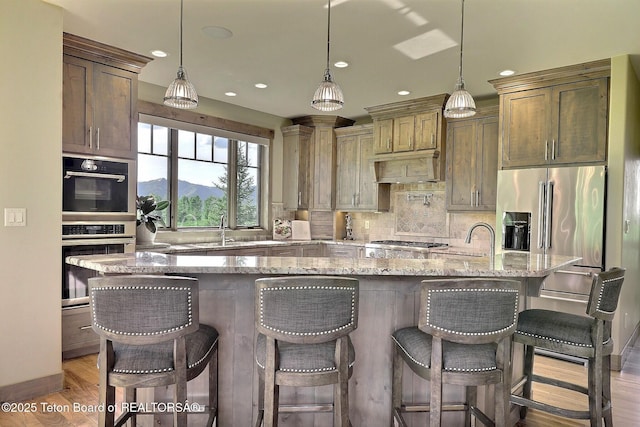 1795 Fumarole Dr, Victor, ID 83455 - kitchen featuring stainless steel appliances, light stone countertops, backsplash, light wood-style flooring, and recessed lighting
