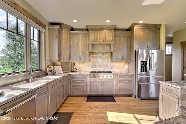 1795 Fumarole Dr, Victor, ID 83455 - kitchen with appliances with stainless steel finishes, light stone counters, light wood-style flooring, backsplash, and recessed lighting