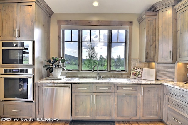 1795 Fumarole Dr, Victor, ID 83455 - kitchen featuring stainless steel appliances, light stone counters, decorative backsplash, and recessed lighting