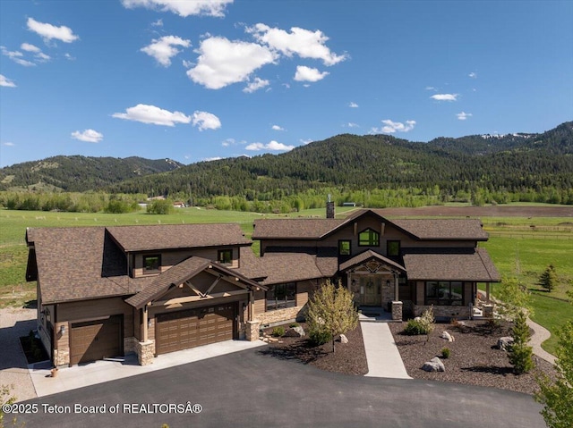 1795 Fumarole Dr, Victor, ID 83455 - view of front facade with stone siding, a mountain view, and a forest view