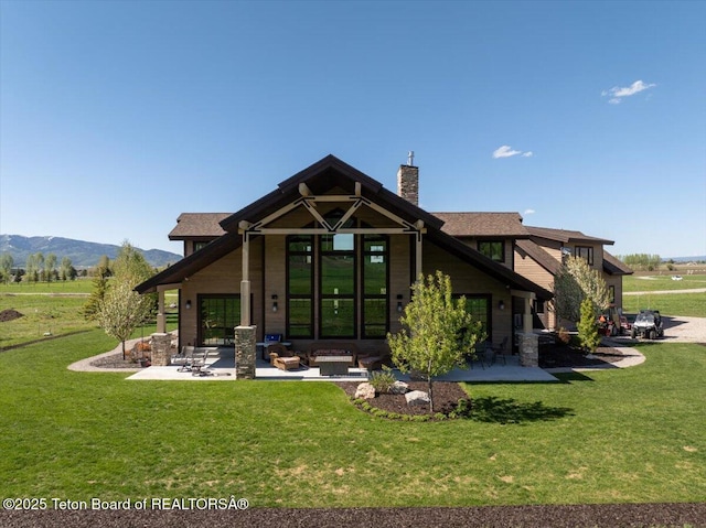 1795 Fumarole Dr, Victor, ID 83455 - back of house featuring a chimney, a lawn, a patio area, and a mountain view
