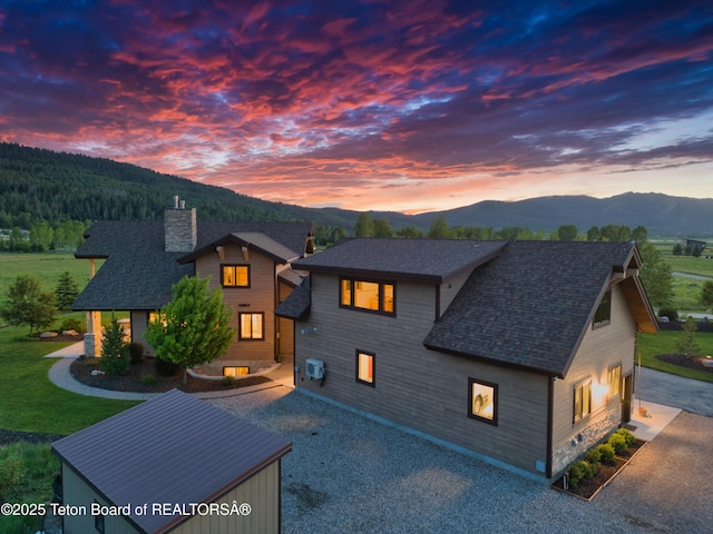 1795 Fumarole Dr, Victor, ID 83455 - view of front facade with a mountain view, a chimney, and a shingled roof