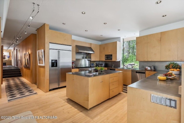 2825 S Sparrow Hawk Rd, Wilson, WY 83014 - kitchen with stainless steel appliances, wall chimney exhaust hood, track lighting, light brown cabinetry, and dark countertops