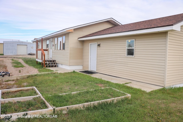 510 Rakestraw Ave, Marbleton, WY 83113 - back of house with a lawn, an outdoor structure, and a shingled roof