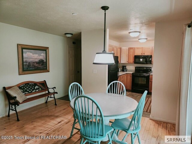 7580 Mountain Laurel Dr Unit A-3, Victor, ID 83455 - dining space featuring light wood finished floors, baseboards, and a textured ceiling