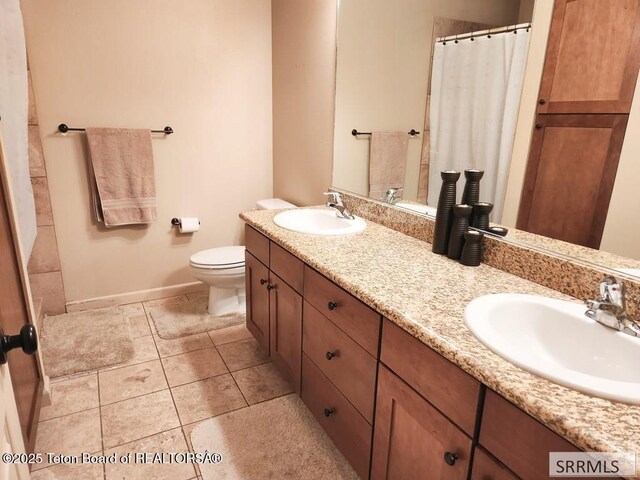 7580 Mountain Laurel Dr Unit A-3, Victor, ID 83455 - bathroom with double vanity, toilet, tile patterned floors, baseboards, and a shower with shower curtain