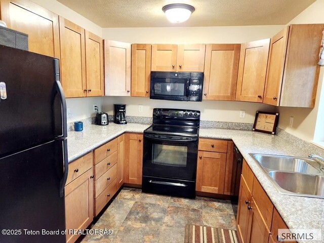 7580 Mountain Laurel Dr Unit A-3, Victor, ID 83455 - kitchen with black appliances, a sink, light countertops, stone finish flooring, and a textured ceiling