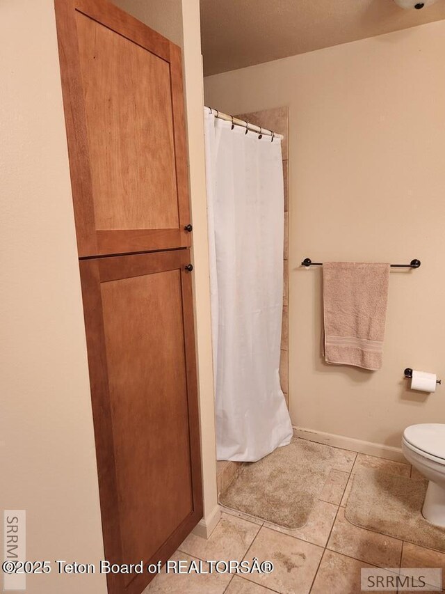 7580 Mountain Laurel Dr Unit A-3, Victor, ID 83455 - bathroom featuring toilet, tile patterned flooring, a shower with curtain, and baseboards