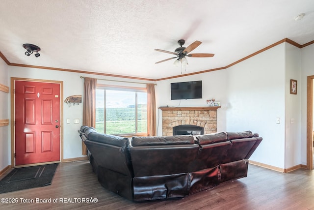 58 Blackhawk Trl, Boulder, WY 82923 - living area featuring dark wood-style flooring, crown molding, ceiling fan, baseboards, and a stone fireplace